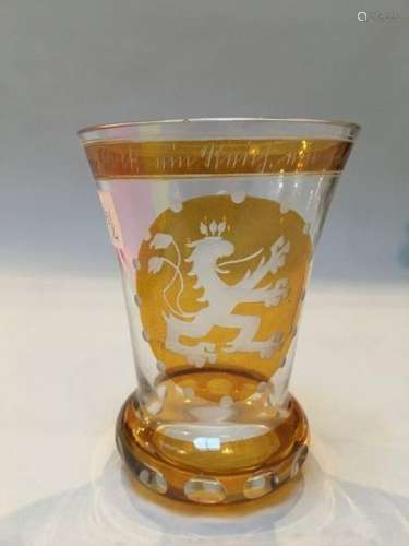 Glass with lion decoration on a yellow background …