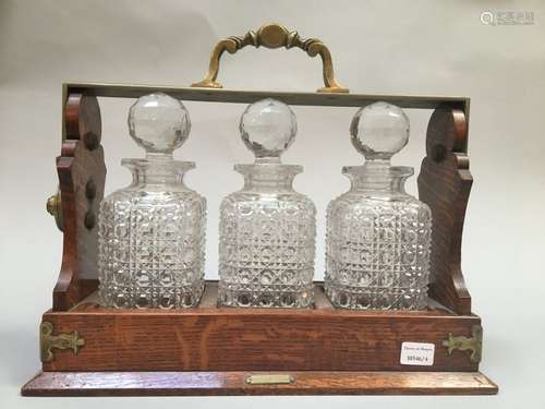 Three alcohol decanters in a wooden display stand …