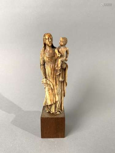 Vierge à l'Enfant en ivoire sculpté en ronde-bosse, patine brune. Debout, Marie [...]