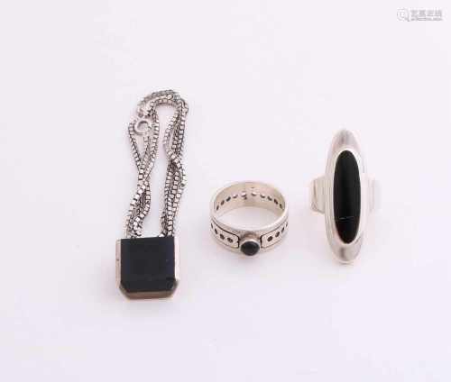 Three silver jewelry with onyx, 925/000, a band ring with round zetkast and onyx, oval ring with