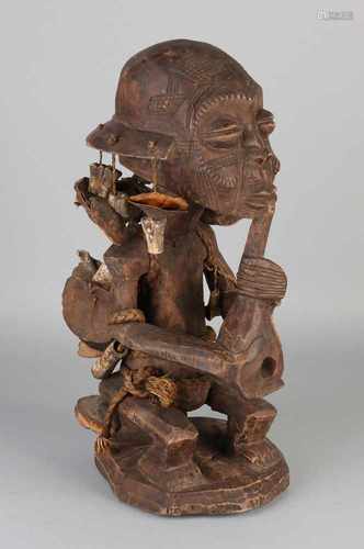 Large African softwood inserted pipe smoking figure with shells. 20th century. Size: H 39 cm. In