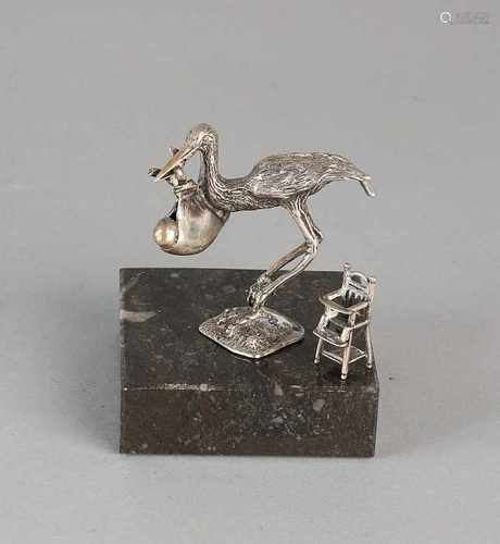 Two silver miniatures, 835/000, a small high chair, and a miniature 1x1x2,5cm stork with baby in the