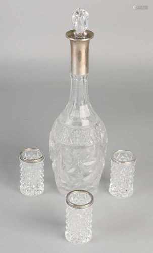 Crystal decanter and three glasses with silver border, 800/000. Decanter with various grinding works