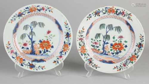 Two 18th century Chinese Imari plates with garden decor. Both hair line + one chip. Size: ø 23 cm.