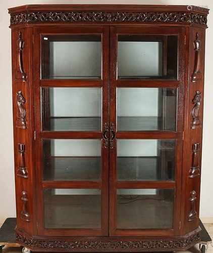 Octagonal teak two-door display cabinet with faceted glass and chess pieces cut figures. Second half