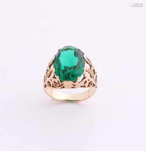 Ornate yellow gold ring, 585/000, with green stone. Ring with a round openwork band, in the middle