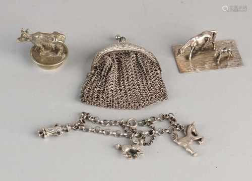 Lot with a silver charm bracelet features three beads and a silver miniature of a horse with a foal,