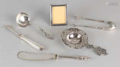 Lot silver include a small picture frame, a tea strainer, a cream spoon, sugar tongs, a butter knife