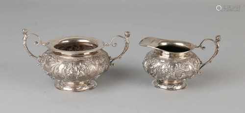 A small set of silver cream, 833/000, 2 part with a milk jug and suikerbak, round model decorated