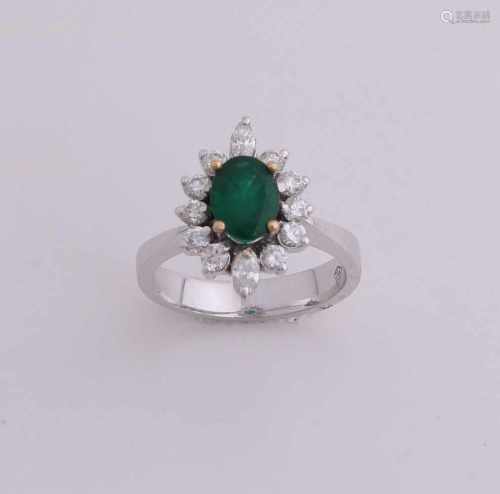 White gold ring, 750/000, with diamond and emerald. Solid ring is provided with an oval rosette with