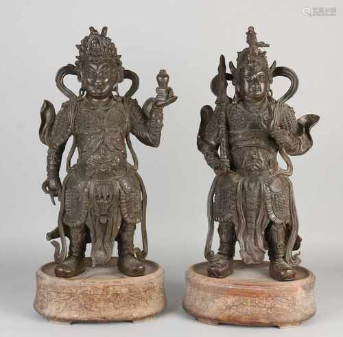 Two major Chinese bronze temple guards on wooden console. First half 20th century or older. Size: