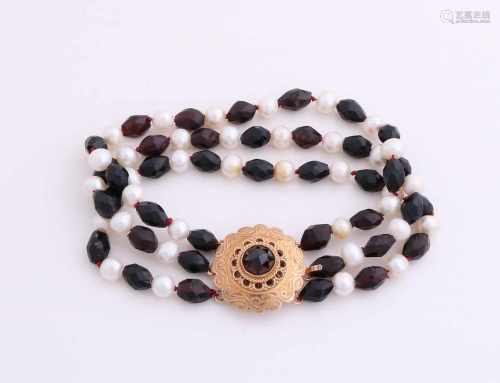 Bracelet with garnet and pearl is provided with a closure golden yellow, 585/000. Bracelet with 3