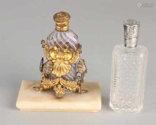 Two perfume bottle, including a special bottle from Murano glass with wire decor, placed in a