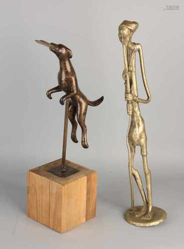 Two bronze figures. Consisting of one large African figure + dog frisbee packed. Mounted on a wooden