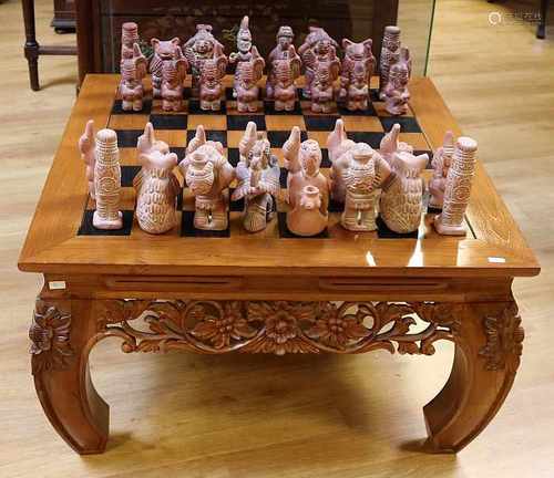 Large South American terracotta chess with beautiful oriental wooden table inserted as a chessboard.