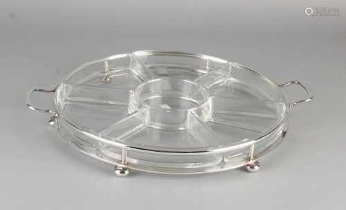 Round glass serving dish with distribution boxes placed in a silver round container 6 ball feet.