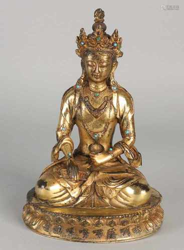 Chinese gilt bronze Buddha sitting on lotus. With Chinese characters and swastika. Size: 18 x 12 x