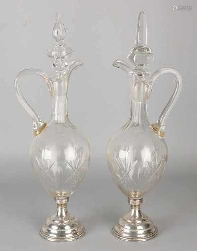 Two crystal decanters donate grinding, posted round silver feet fitted with pearl border. 833/000.