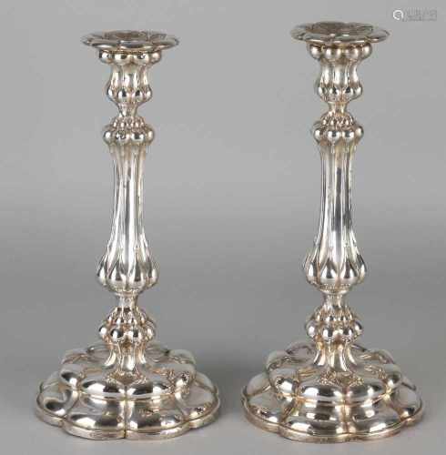 Two silver table candlesticks 800/000, on a round scalloped base with lobed operation over the