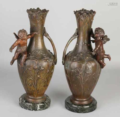 Two antique metal composition patinated bronze Art Nouveau vases with putti and floral decor. On