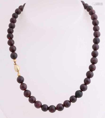 Collier faceted garnets, ø 8.5 mm, mounted on an oval yellow gold clasp, 585/000. Length 42 cm. In