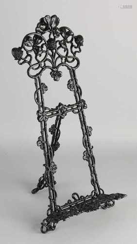 Metal easel in art nouveau style. Whip with floral decor. Second half 20th century. Size: 46 x 22