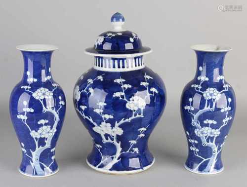 Three piece Chinese porcelain garniture with blossom decor. One vase edge damage, vase well. Size: