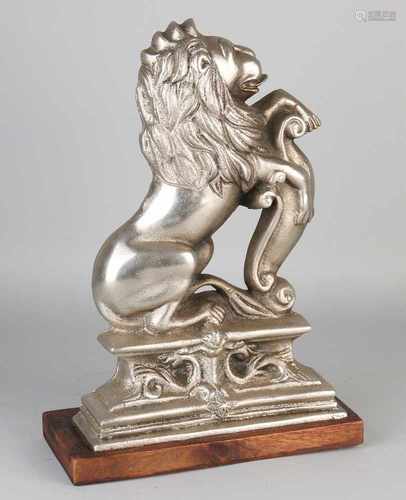 Heavy nickel-plated cast iron doorstop in the shape of a lion. Mounted on oak basement. Circa