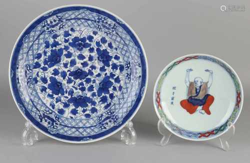 Two Chinese porcelain plates. One sign of monks, six signs bottom mark. One plate with peonies.