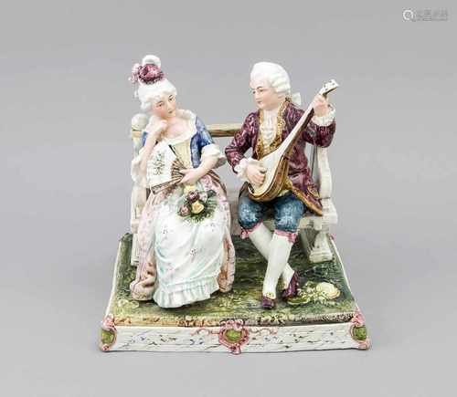 Ceramic figures group. Man with lute on the bench next to woman in 18th century costumes.