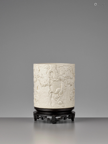 A MOLDED CREAM-GLAZE BRUSH POT, QING DY…