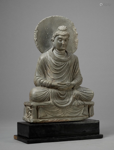 A GRAY SCHIST FIGURE OF A SEATED BUDDHA, GAN…