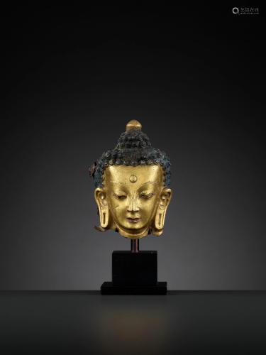 A GILT COPPER REPOUSSE HEAD OF BUDDHA…