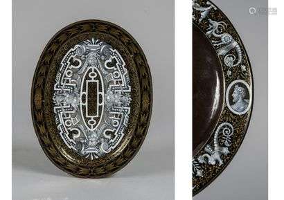 Small Oval Dish in enamel on copper decorated with cartouches, cut leather and masks or terms on a black background decorated with gold scrolls. The wing is decorated on the reverse with grotesques and por-traits in medallions.Limoges, 16th century style.Length : 25 cm - Depth : 19 cm(Small enamel jumps and gaps, restorations)