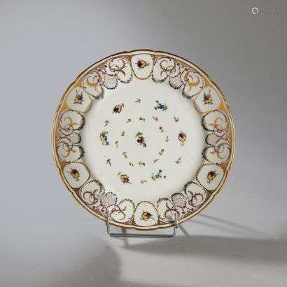 BORDEAUXPorcelain plate with contoured rim with polychrome decoration of seedlings of flowers and pansies in the center and on the wing of garlands of flowers, pansies and foliage scrolls.Marked: W in gold.Manufacture of Verneuilh and Vanier.18th century. Diameter : 24 cm