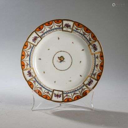 PARIS OR BRUSSELSPorcelain plate with contoured rim with polychrome decoration of a butterfly in the centre in a medallion and on the butterfly wing in six vignettes surrounded by garlands of roses, braid with an orange background on the rim.Marked: B in gold.End of the 18th century. Diameter : 24,5