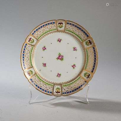 PARISPorcelain plate with contoured rim with polychrome decoration of rose seedlings in the center and on the pansy wing in reserves surrounded by pearls, garlands of leaf-lage and gold scrolls.Unmarked.Late 18th century. Diameter : 23,5