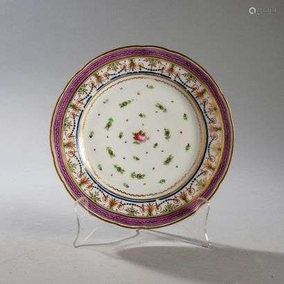 PARISPorcelain plate with contoured rim with polychrome decoration of rose seedlings in the center and on the wing of garlands of pearls, foliage and festoon with mauve background.Without mark.Late 18th century. Diameter : 24,5 cm(Some wear and tear)