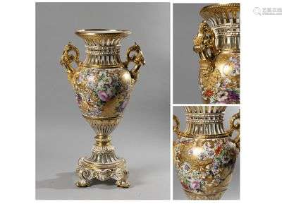 RUSSIA or AUSTRIALarge baluster-shaped porcelain vase with an openwork base and neck, the square base resting on four rocaille and shell feet, with polychrome decoration of large bunches of flowers and birds and floral scrolls in gold, the golden-bottomed handles formed by satyr masks ending in acanthus leaf and surmounted by fruit and scrolls.First half of the 19th century. Top. : 64,4 cm(Restorations to the base and some gold wear)