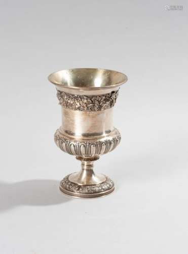 Cup on a silver pedestal, the base of the body with gadroons and tabs with fleur-de-lys, the neck underlined by a frieze decorated with vine branches on an amati background, the foot decorated with a leafy frieze on an amati background. The inside is in vermeil. London, 1823Height 15.5 cmWeight: 373 g