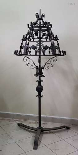 Large conical cast iron steel pick set on a tripod-shapedhelical base decorated with fleur-de-lys and foliage.High. 170 cm approx.