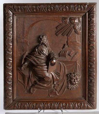 Carved oak panel depicting the holy evangelist Mark, the lion lying at his feet.In a frame with acanthus leaves.Late 17th-early 18th century.52 x 46 cm(Cracks, small filler)