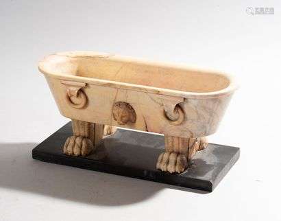 Ovoid bowl in the shape of a bathtub in Antique style in pinkish beige marble decorated with lion heads and rings. It rests on four clawed legs on a rectangular black marble base.Italy, circa 1830.High. 14.5 cm - Length : 29 cmDepth: 12.5 cm(Missing, small splinters)