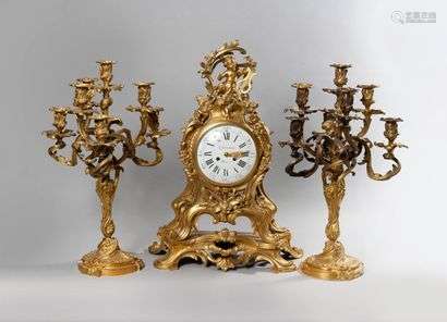 Large chased and gilded bronze mantel set comprising a cartel and a pair of seven-light candelabra. Dial signed Lefaucheur. Rococo style 19th centuryHigh. Pendulum: 66 cm - Height. Candelabrum : 60 cm