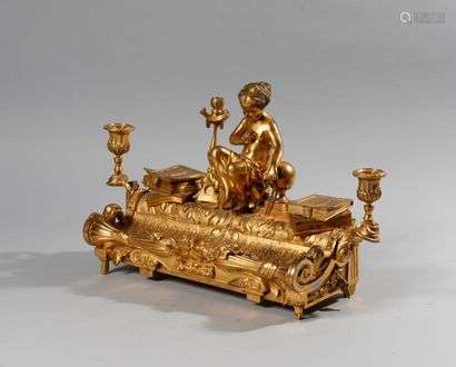 Inkwell in chased and gilded bronze representing the alegory of science surrounded by two piles of books hiding the inkwells all surrounded by two arms of light. It opens by a side drawer. Louis XVI style second half of the XIXth century High. Height: 28 cm - Width: 47 cmDepth: 19 cm