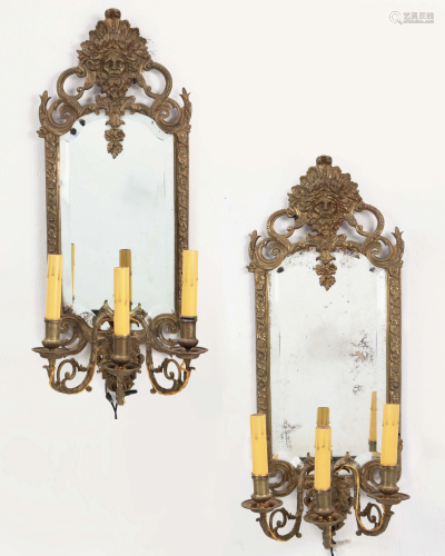 A pair of gilt brass mirror back wall sconces