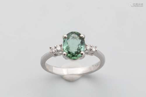 18k white gold ring set with a green oval cut tour…