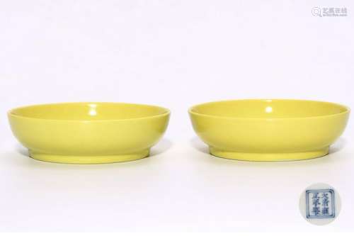 A PAIR OF CHINESE YELLOW GLAZED PORCELAIN SAUCERS