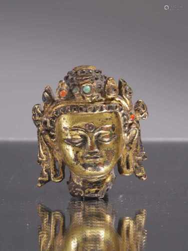 HEAD OF BUDDHABronze fire gilt with turquoise und semi precious stonesNepal , 14th