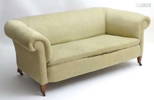 A late 19thC Chesterfield sofa raised on square legs terminating in brass castors.